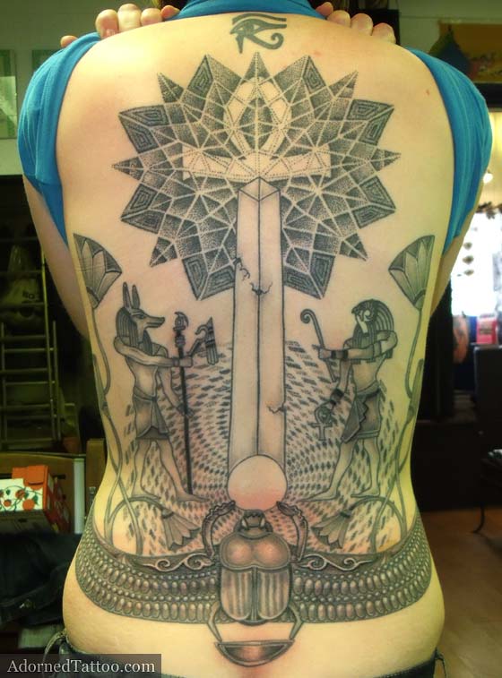 Steph's Egyptian back tattoo features geometric dotwork patterns Anubis