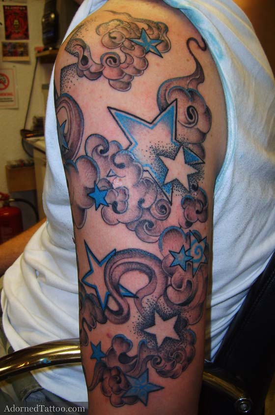 Terry's upper arm tattoo features stars and smokey clouds with a hint of